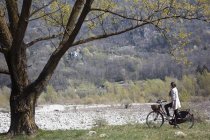 Jovem ciclista feminina olhando para a cena rural — Fotografia de Stock