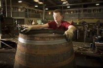 Young man making whisky cask at cooperage — Stock Photo