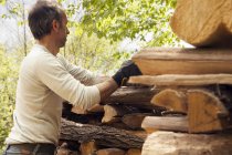 Mann stapelt geschnittenes Holz — Stockfoto
