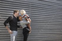 Famiglia in piedi da muro clapboard, madre che tiene figlio — Foto stock