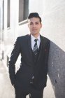 Young businessman leaning against wall — Stock Photo