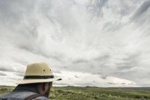 Cabeza y hombros de hombre con sombrero de panama mirando hacia el paisaje, Cody, Wyoming, EE.UU. - foto de stock