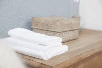 Close up de pilha de toalhas e caixa na cômoda — Fotografia de Stock