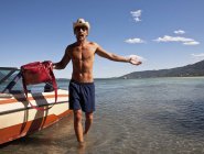 Junger Mann trägt Tasche von Motorboot, Verbania, Italien — Stockfoto