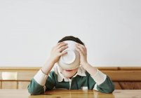 Junge trinkt Milch aus Schüssel — Stockfoto