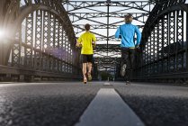 Amici che fanno jogging sul ponte, Monaco, Baviera, Germania — Foto stock
