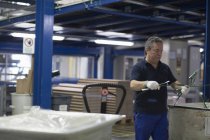 Homem sênior trabalhando no interior da fábrica — Fotografia de Stock