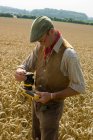 Mature farmer testing in field of wheat — Stock Photo
