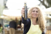 Market trader with bottle of olive oil — Stock Photo