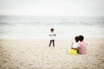 Pareja e hijo tomando fotografías en la playa - foto de stock