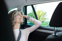Senior businesswoman looking through car window — Stock Photo