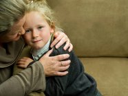 A young girl being hugged by her mum — Stock Photo