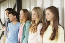 Fila di cinque ragazze e ragazzi che guardano fuori dal rifugio — Foto stock
