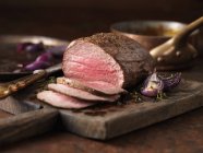 Steak de châteaubriand servi avec oignons rôtis, poivre et herbes — Photo de stock