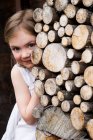 Mädchen versteckt sich hinter Baumstämmen. — Stockfoto