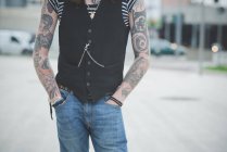 Tiro cortado de jovem hippie masculino com braços tatuados — Fotografia de Stock