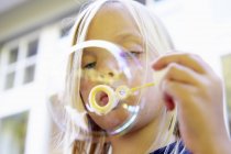 Portrait of Girl blowing bubbles — Stock Photo