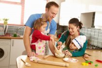 Familie bereitet Plätzchen in Küche zu — Stockfoto