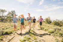 Adolescente y amigos adultos corriendo en pista de tierra, Bridger, Montana, EE.UU. - foto de stock