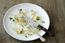 Empty plate with leftover peas — Stock Photo
