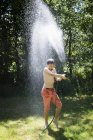 Boy playing with garden hose — Stock Photo