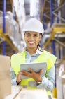 Young woman with digital tablet in distribution warehouse — Stock Photo