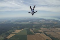 Male skydiver freeflying upside down above Siofok, Somogy, Hungary — Stock Photo