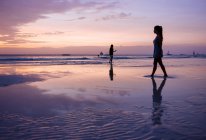 Силуэт молодая женщина прогуливаясь по пляжу на закате, остров Боракай, Visayas, Филиппины — стоковое фото