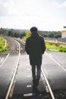 Visão traseira do homem adulto médio em pé na travessia ferroviária — Fotografia de Stock