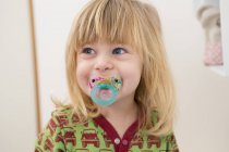 Portrait of  happy two year old girl with pacifier — Stock Photo