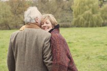 Rear view of couple hugging on meadow — Stock Photo