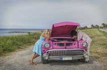 Junges paar versucht, ein vintage cabrio an der küste, havana, kuba reparieren — Stockfoto