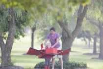 Father preparing toy airplane for son in park — Stock Photo