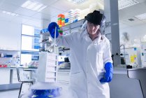 Laboratoire de recherche sur le cancer, chercheuse plaçant des cellules dans une chambre de cryoconservation d'azote liquide — Photo de stock