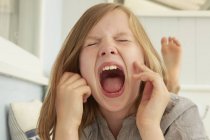 Menina com os olhos fechados gritando no apartamento de férias — Fotografia de Stock