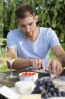 Metà uomo adulto seduto al tavolo da picnic in giardino — Foto stock