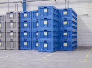 Vue des caisses bleues empilées en usine — Photo de stock