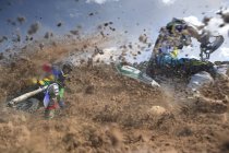 Two male motocross riders racing through mud — Stock Photo