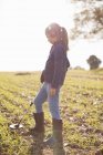 Девушка в наушниках с помощью металлоискателя в поле — стоковое фото