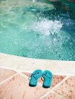 Vista de chinelos na borda da piscina — Fotografia de Stock