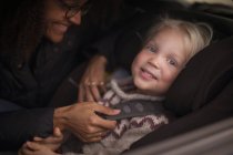 Мать пристегивает сына ремнем безопасности в машине — стоковое фото