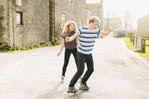 Teenager-Bruder und Schwester skateboarden auf Landstraße — Stockfoto