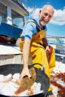 Smiling Fisherman holding fish — Stock Photo