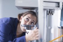 Крупним планом жінка-інженер вивчає машинний клапан на заводі — стокове фото