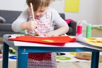Девочка рисует дома на бумаге — стоковое фото