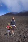 Retrato de mujer e hijo en el Monte Etna, Catania, Sicilia, Italia - foto de stock