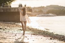 Jeune femme marchant le long de la rivière — Photo de stock