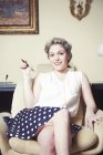 Retrato de mujer joven en sillón con ropa vintage - foto de stock