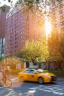Taxi jaune et cycliste sur la route à Park Avenue, New York, États-Unis — Photo de stock