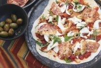 Pizza fatta in casa cruda sul tavolo da giardino — Foto stock